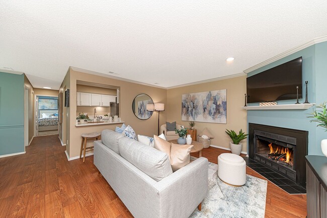 Spacious living room with hardwood-style flooring & fireplace - Vetra at Hamilton Place
